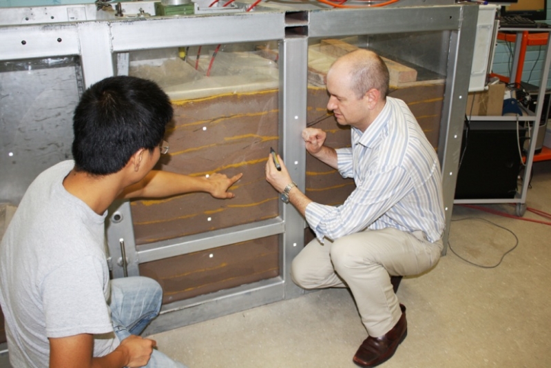 Adrian Russell (right) and Liem Vo observe the laboratory controlled failure of an unsaturated soil adjacent to a retaining wall