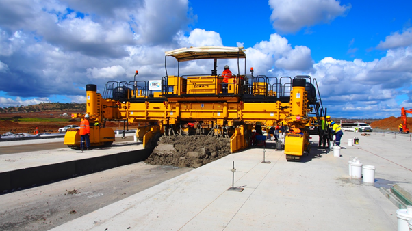 Geopolymer concrete being placed using paving machine.